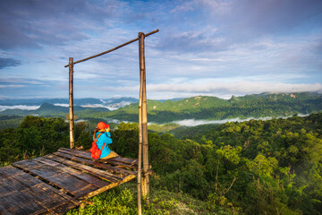 Young girl are taking photos  the sea of mist on high mountain in  Doi-hua-mod, tak province, Thailand.