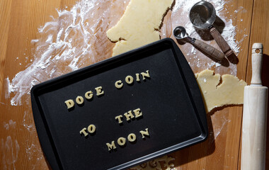 Plaque à biscuit avec écriture en anglais avec de la pâte à biscuit fraichement préparée en forme de lettre avec une expression populaire au sujet de la crypto monnaie jusqu'à la lune - Powered by Adobe