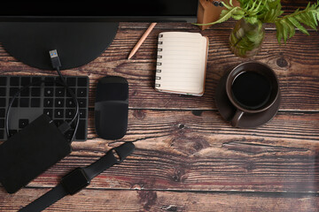 Above view empty notebook, smart watch and coffee cup on wooden table.