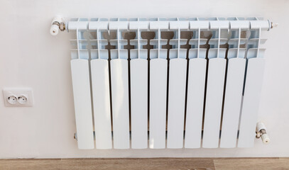 Installing a radiator on a white wall.