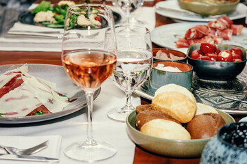 A table in a restaurant. Dinner with wine. Bacon salad. Buns. Table setting.