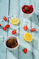 strawberry jam ingredients on blue wooden table
