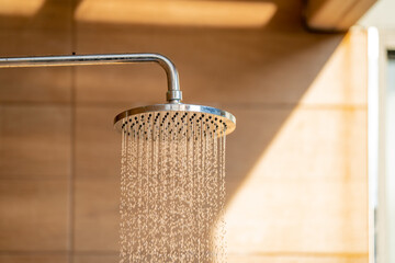 Outdoor shower head for the bath and showering cold water to body before jumping in the resort pool. - obrazy, fototapety, plakaty