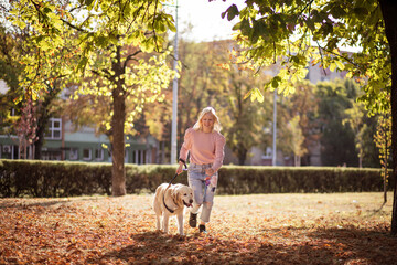 Fototapeta premium Woman running with dog in the park.