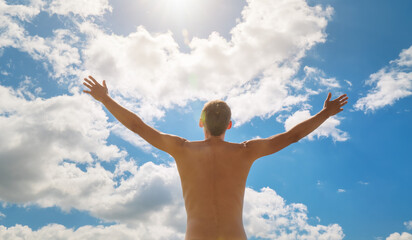 Man strive hands to the deep blue sky and sun.