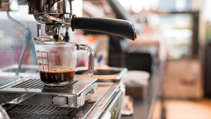 black coffee in measuring cup put on coffee maker