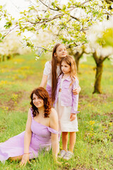 mom and two daughters. A family in a blossoming spring garden. 