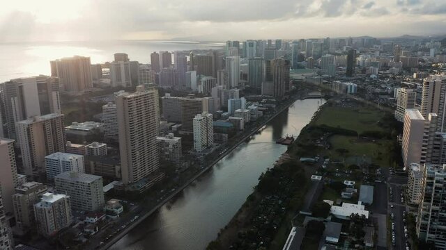 Aerial view of Waikiki neighborhood with tall buildings by Wai Canal at sunset, Hawaii