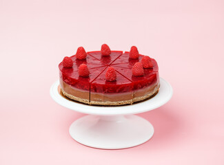 On a pink background, a white cake stand. Healthy Raspberry Layer Cake sugar-free and gluten-free for the diet. On a pink background, a white cake stand.  Space for the text.