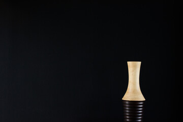 A wooden vase on a dark background. 