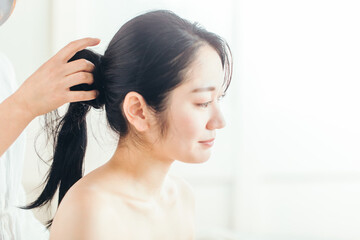 Fototapeta premium ヘアメイク・髪の毛を縛る女性 