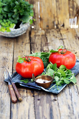 grandes tomates vermelhos maduros com salada de agrião e sal do mar estão em uma bandeja - uma excelente opção para uma dieta saudável.
