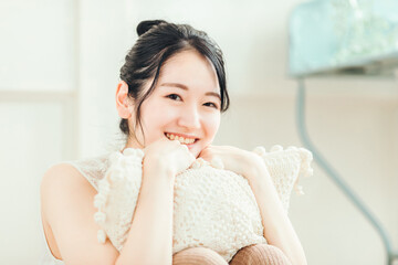 部屋でクッションを抱く女性
