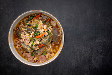 Pad Ka Prao Kai Yeow Ma, Thai food, basil stir fried century egg with pork and ham on dark grey texture background with copy space for text