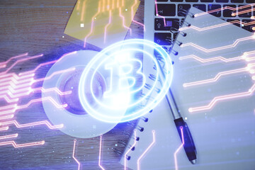 Blockchain theme hologram drawings over computer on the desktop background. Top view. Multi...
