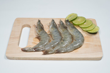 fresh shrimps on wooden cutting board plate. fresh shrimp prawns for cooking with Sliced lemon