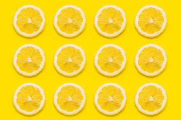 background of ripe lemon slices against on a yellow background. Top view, flat lay