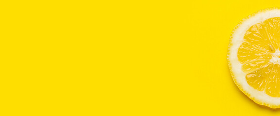 slice of yellow lemon on a yellow background. Top view, flat lay. Banner