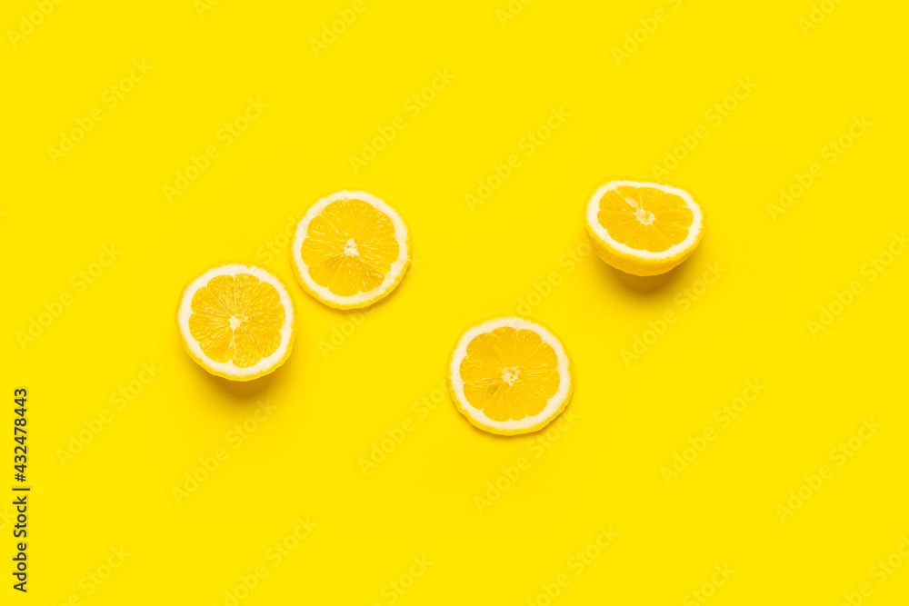 Wall mural lemon wedges and sliced lemon on a yellow background. Top view, flat lay.