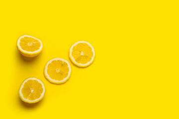 lemon wedges and sliced lemon on a yellow background. Top view, flat lay