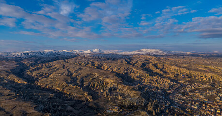 Fototapeta na wymiar Panorama of the landscapes of Cappadocia, Turkey with fairy chimneys, mountains, rock formations and the town of Ürgüp