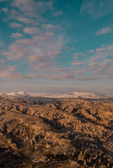 Fototapeta premium Beautiful vertical aerial view of the landscapes of Cappadocia, Turkey with fairy chimneys, mountains, rock formations and the town of Ürgüp