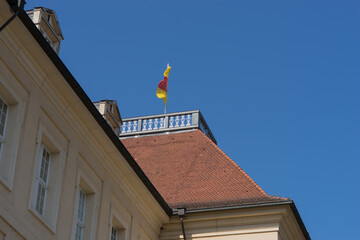 Rooftop with flag of the baroque residence "Karlsburg Castle", blue sky
