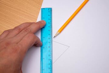 Drawing straight line with pencil and ruler in exercise book