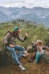 Family travel father and daughter baby high five hands hiking in mountains together summer...