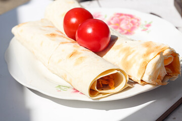 Homemade fresh bread rolls for breakfast on a vintage plate standing under the sun on a balcony. weekend countryside activities