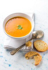 Delicious and creamy pumpkin soup served with    bread croutons. Food photography of vegetarian, healthy soup.