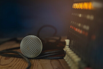 A microphone and professional audio mixer on a wooden table.