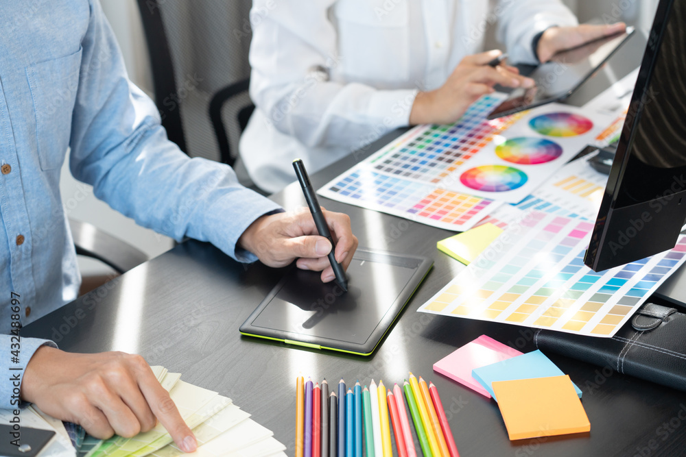 Aufkleber graphic designer or creative working together coloring using graphics tablet and a stylus at desk wi