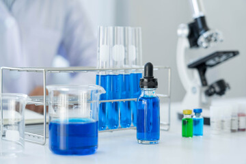 Scientist wear lab coat and protective wear are working with research or doing investigations with test tubes in experiment, Laboratory and development concept