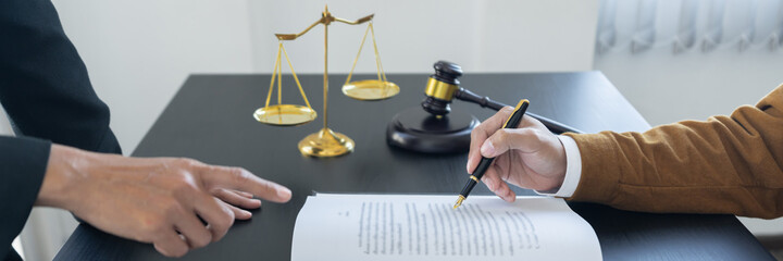 law,libra scale and hammer on the table, 2 lawyers are discussing about contract paper, law matters...