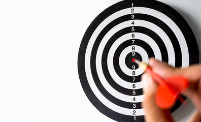 Businessman hand holding a darts aiming and try to throw to target. business goal concept -...