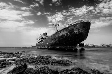 Wrecked ship on a rocky shore. Very dramatic black and white image