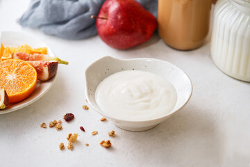 Homemade breakfast fresh colorful decoration mixed yogurt granola with mango, fig, cereal, rosemary, mint on white background