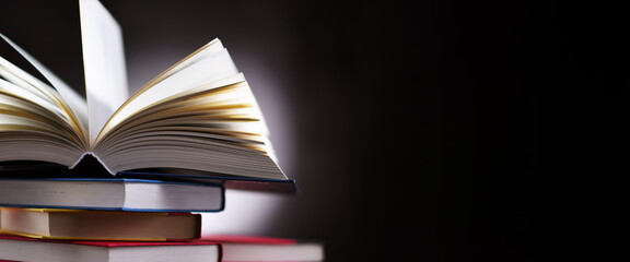 A composition with an open book lying on a stack of other books
