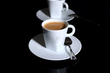White cup of coffee on a black background
