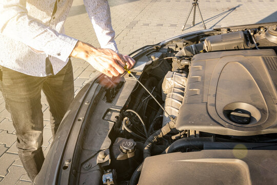 Engine problem. Driver man near open hood vehicle broken down on road. Auto motor car problem concept. - Powered by Adobe
