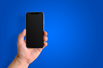 Man holding mobile phone, close-up of hand