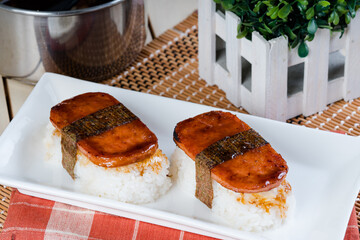 Spam musubi is a popular snack and lunch food in Japan that composed of spam on top of rice wrapped with thick or thin nori