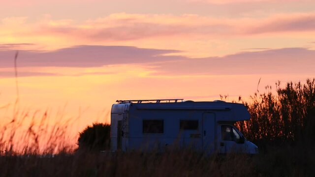 Caravan, recreational vehicle camping on seaside meadow field at sunrise. Capi Corb location, Valencia, Mediterranean coast of Spain. Traveling by motorhome.
