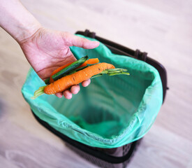 separating biowaste in the apartment, throwing pieces of vegetables into a decomposable bag
