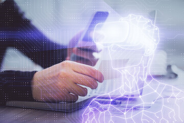 Double exposure of man's hands holding and using a digital device and AR glasses drawing. Virtual reality concept.