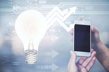 Double exposure of light bulb hologram and woman holding and using a mobile device. Idea concept.