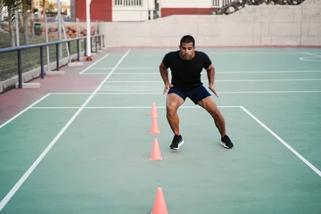 Foto auf Alu-Dibond Hispanic man doing speed and agility cone drills workout session outdoors - Focus on man face © DisobeyArt