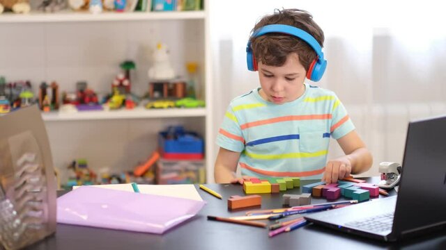 boy doing logic exercises at home communicating with the teacher via video communication