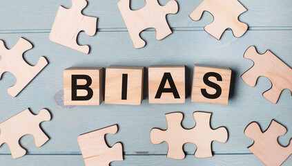 Obraz premium Blank puzzles and wooden cubes with the text BIAS lie on a light blue background.